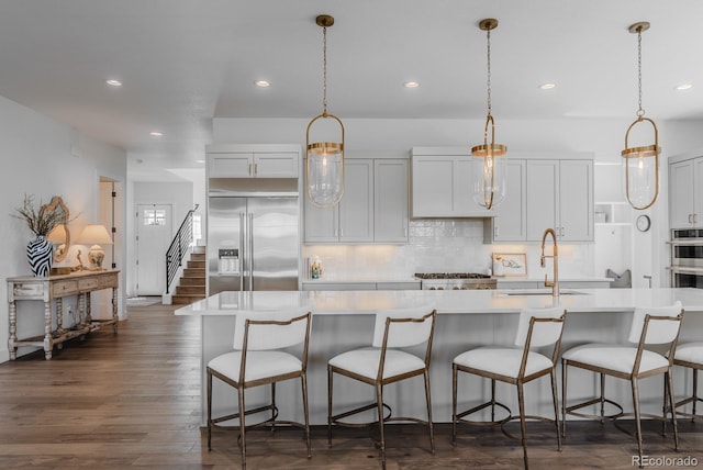 2141 Fountain Cir, Erie, CO 80516 - kitchen with appliances with stainless steel finishes, a sink, light countertops, recessed lighting, and decorative backsplash