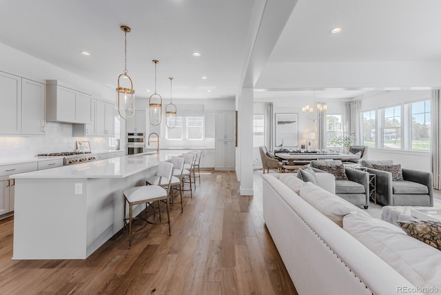 2141 Fountain Cir, Erie, CO 80516 - living room with a chandelier, light wood-type flooring, and recessed lighting