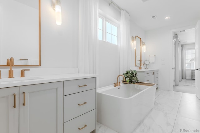 2141 Fountain Cir, Erie, CO 80516 - full bath featuring marble look tiles, healthy amount of natural light, a soaking tub, two vanities, and recessed lighting