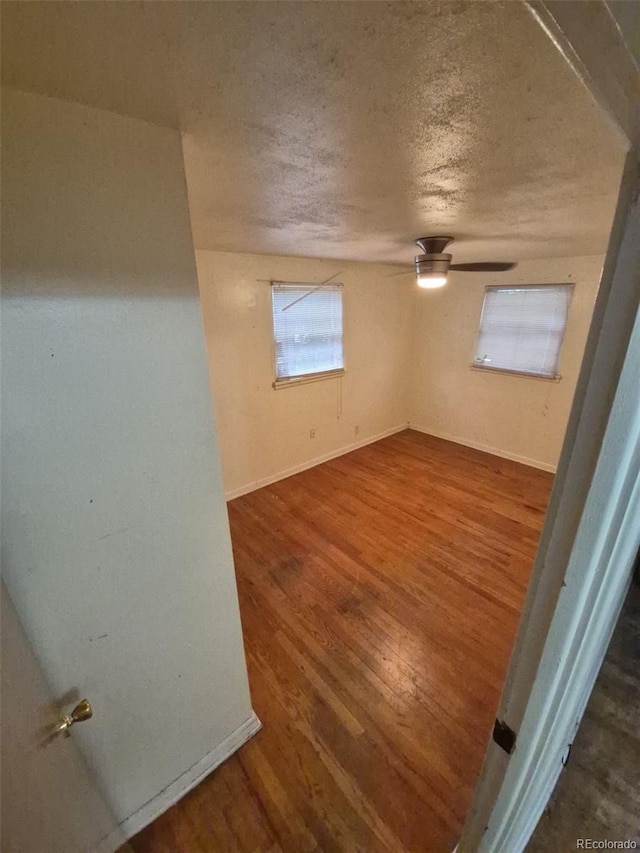 1078 Elmira St, Aurora, CO 80010 - unfurnished room with wood finished floors, a textured ceiling, baseboards, and a ceiling fan
