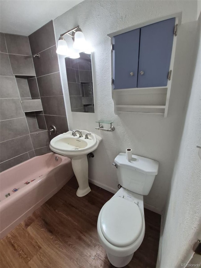 1078 Elmira St, Aurora, CO 80010 - full bath featuring wood finished floors, toilet, shower / bathtub combination, baseboards, and a textured wall
