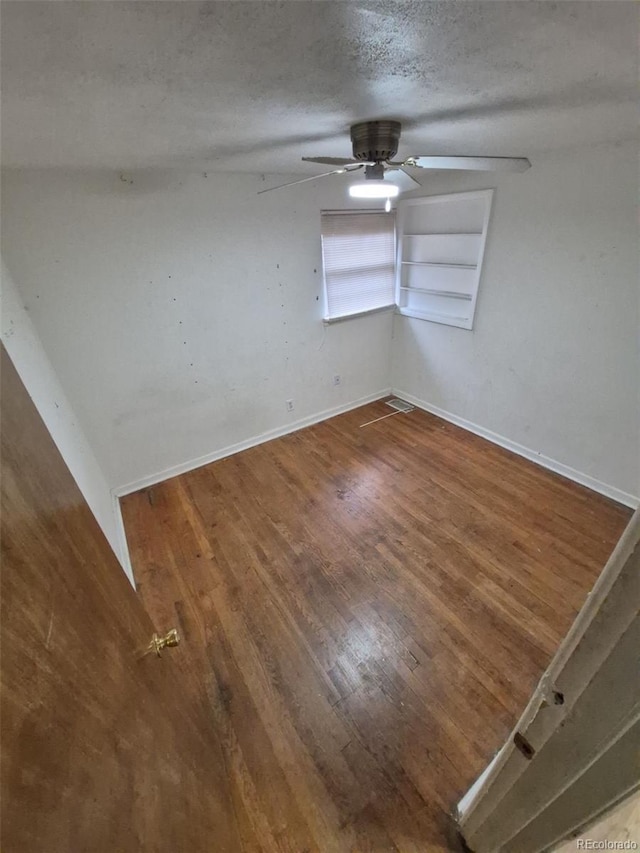 1078 Elmira St, Aurora, CO 80010 - unfurnished room with baseboards, wood finished floors, a ceiling fan, and a textured ceiling
