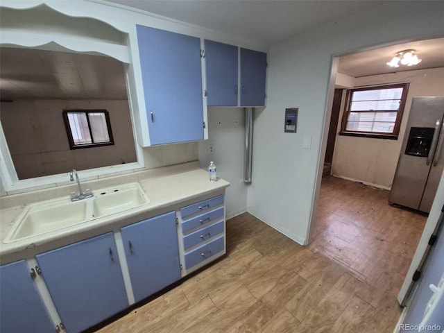 1078 Elmira St, Aurora, CO 80010 - kitchen with blue cabinets, stainless steel fridge with ice dispenser, a sink, and light wood finished floors