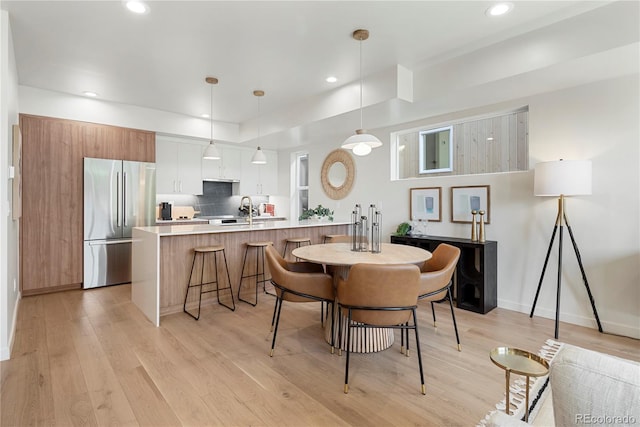 dining room with sink and light hardwood / wood-style flooring