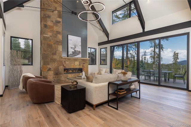 living room with light hardwood / wood-style flooring, high vaulted ceiling, and plenty of natural light