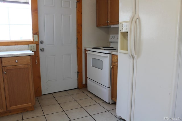 933 Skeel St, Brighton, CO 80601 - kitchen featuring white appliances, light countertops, light tile patterned floors, and brown cabinets