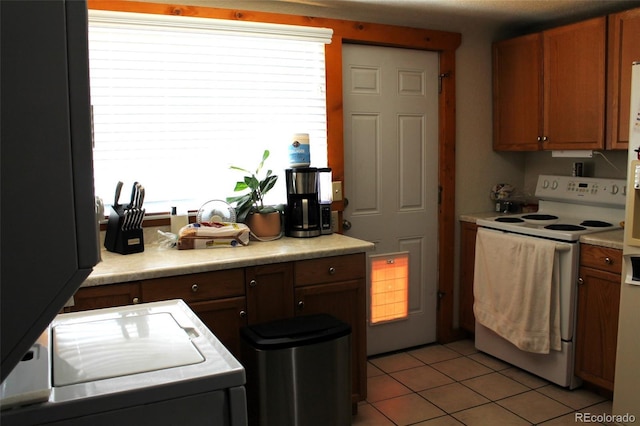 933 Skeel St, Brighton, CO 80601 - kitchen with white range with electric cooktop, light tile patterned flooring, light countertops, and plenty of natural light