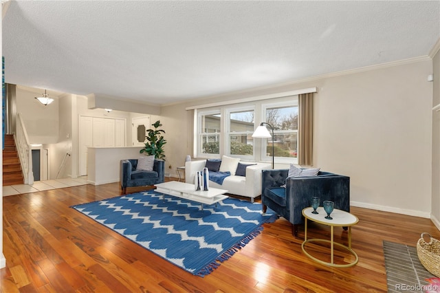 living room with a textured ceiling, light wood-type flooring, and crown molding