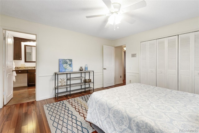 bedroom with dark hardwood / wood-style flooring, ensuite bathroom, a textured ceiling, ceiling fan, and a closet