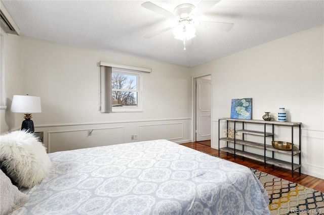 bedroom featuring a textured ceiling, dark hardwood / wood-style flooring, and ceiling fan