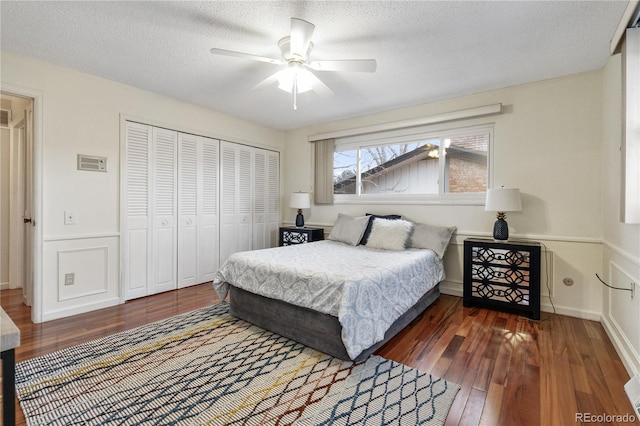 bedroom featuring a textured ceiling, dark hardwood / wood-style flooring, a closet, and ceiling fan