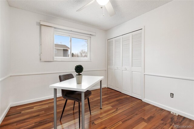 office space featuring ceiling fan, dark hardwood / wood-style floors, and a textured ceiling