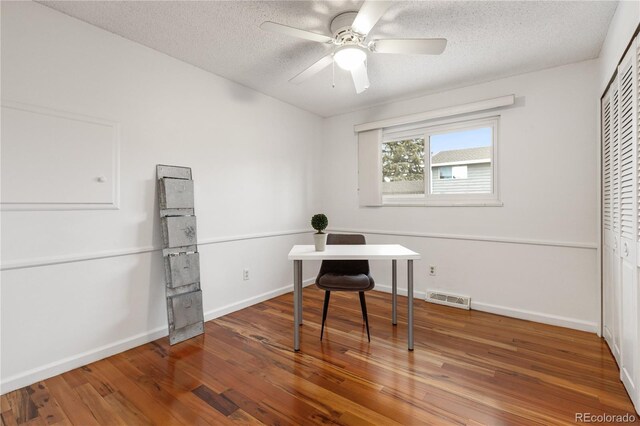 office area with ceiling fan, wood-type flooring, and a textured ceiling