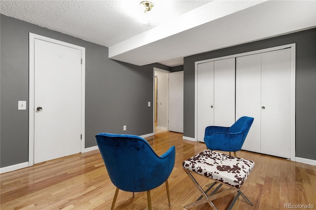 living area featuring light hardwood / wood-style flooring and a textured ceiling