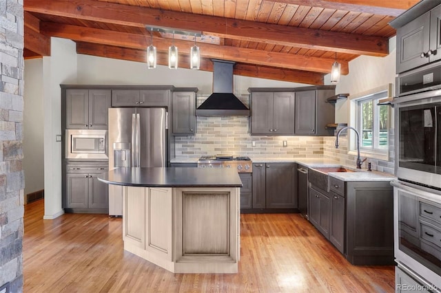 kitchen featuring pendant lighting, wall chimney exhaust hood, stainless steel appliances, and a kitchen island