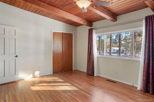 unfurnished bedroom featuring ceiling fan, a closet, wood ceiling, and light wood-type flooring