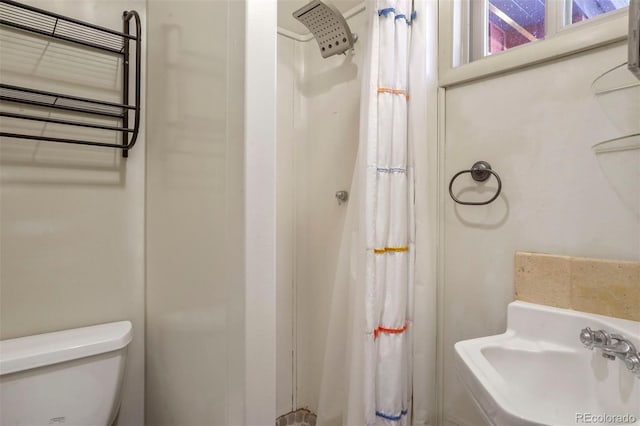 bathroom with a shower with curtain, toilet, and sink