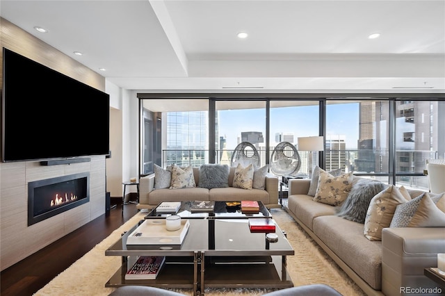 living room with a tile fireplace and dark hardwood / wood-style floors