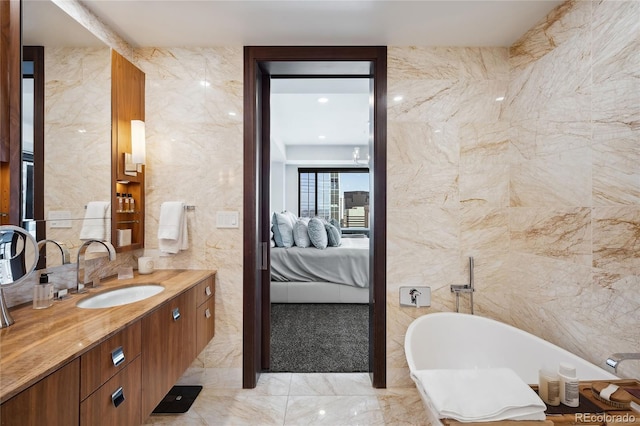 bathroom with tile walls, vanity, and a tub