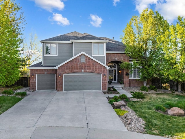 traditional-style house featuring concrete driveway, a garage, brick siding, and a shingled roof
