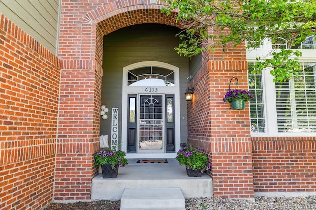 view of exterior entry with brick siding
