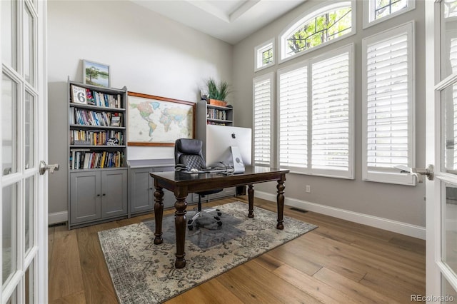 office space featuring wood finished floors, baseboards, and french doors