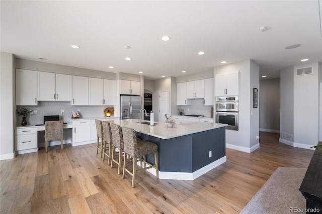 kitchen featuring appliances with stainless steel finishes, backsplash, white cabinetry, and recessed lighting