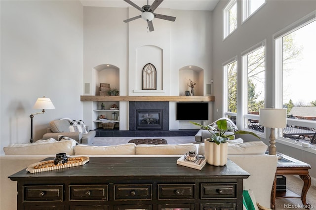 living area with a towering ceiling and a ceiling fan