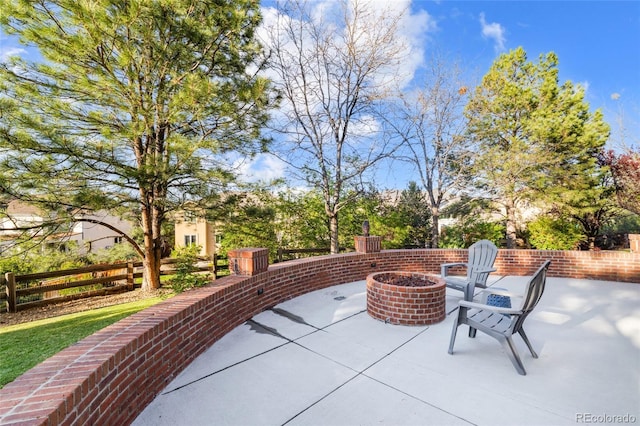 view of patio with a fire pit and fence
