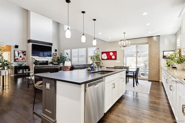 kitchen featuring a kitchen island with sink, pendant lighting, white cabinets, and stainless steel dishwasher