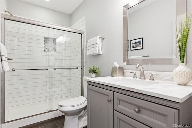 bathroom with vanity, an enclosed shower, and toilet