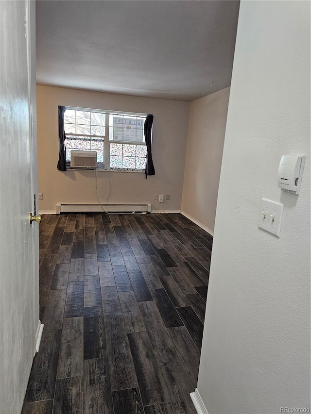 unfurnished room featuring cooling unit, dark wood-type flooring, and baseboard heating