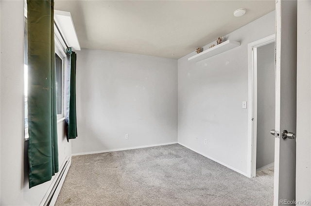 carpeted empty room featuring a baseboard heating unit