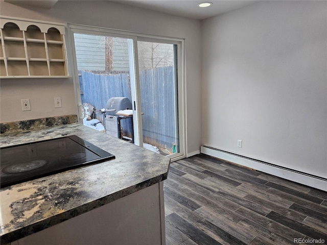 kitchen with dark hardwood / wood-style flooring, black electric cooktop, and baseboard heating