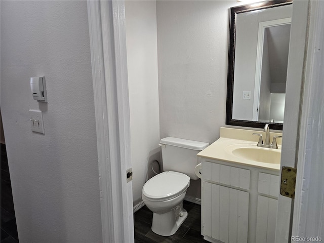 bathroom with vanity, hardwood / wood-style flooring, and toilet