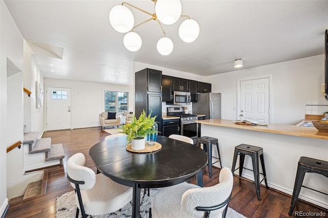 dining space with an inviting chandelier and dark hardwood / wood-style floors