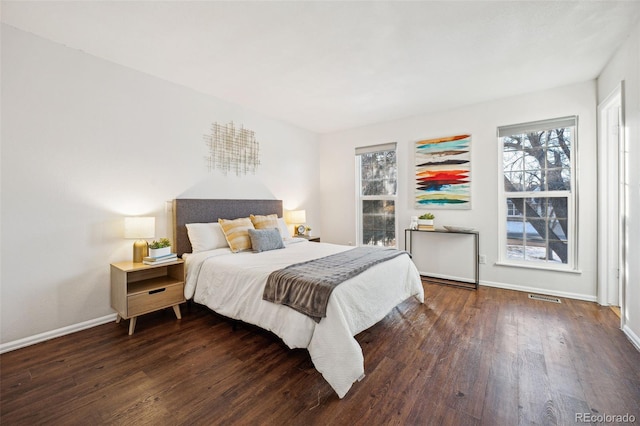 bedroom with dark hardwood / wood-style flooring