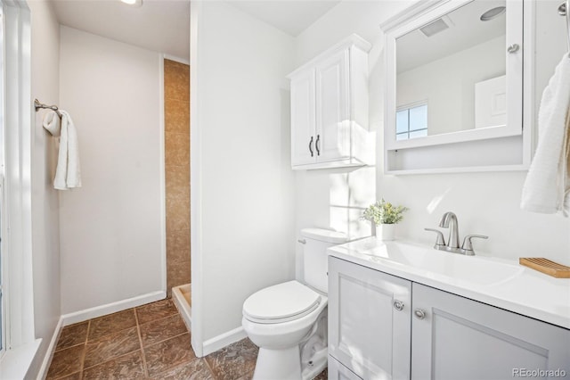 bathroom with toilet, a shower, and vanity