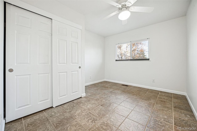 unfurnished bedroom featuring ceiling fan and a closet