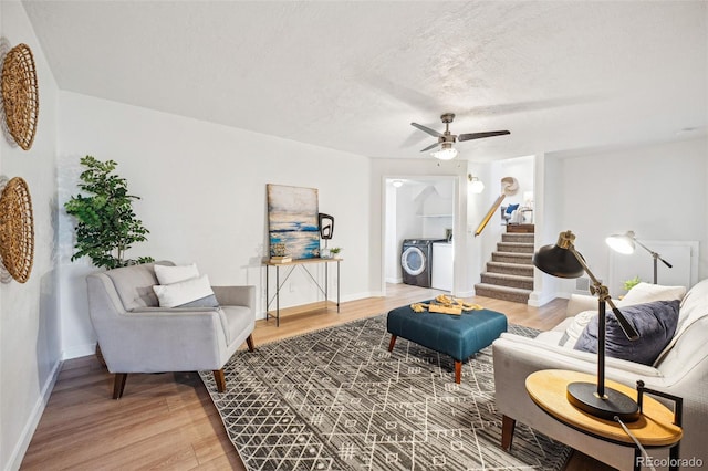 living room featuring ceiling fan, washer and clothes dryer, hardwood / wood-style floors, and a textured ceiling