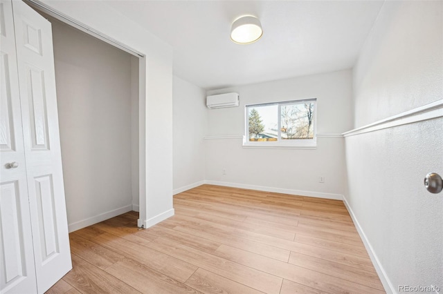 interior space with a wall mounted air conditioner and light hardwood / wood-style flooring