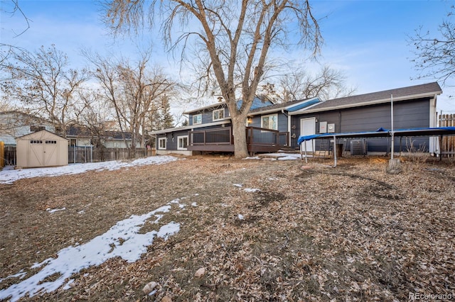 snowy yard featuring central AC unit and a storage shed