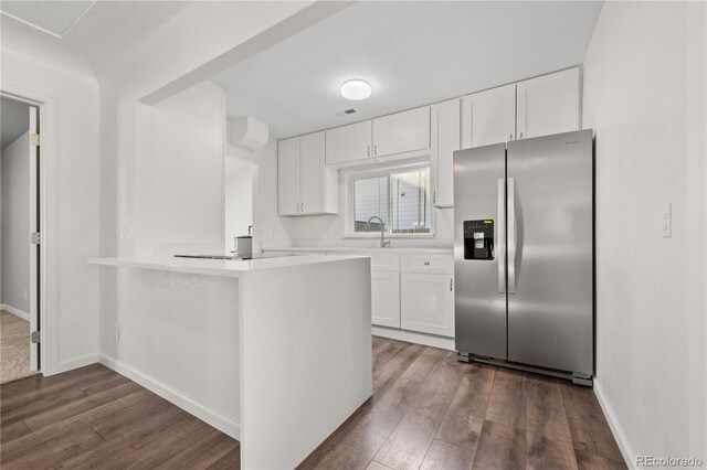 kitchen featuring stainless steel fridge with ice dispenser, kitchen peninsula, dark hardwood / wood-style flooring, and white cabinets