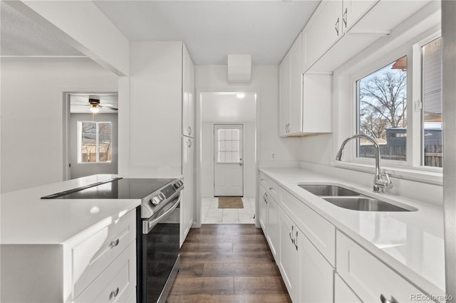 kitchen featuring ceiling fan, sink, white cabinetry, and stainless steel range with electric cooktop