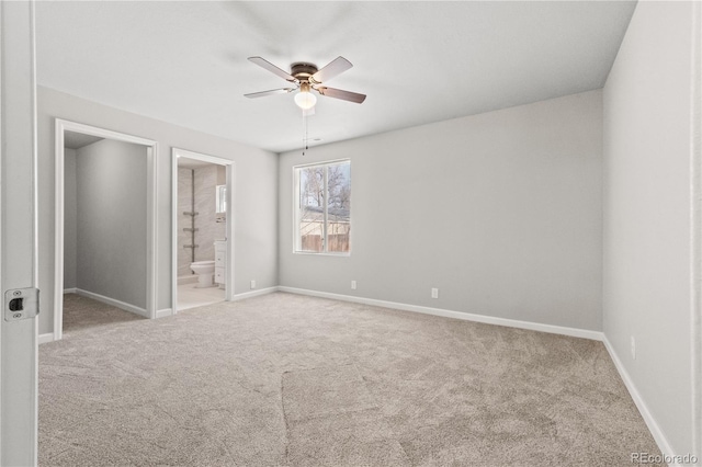 unfurnished bedroom featuring ceiling fan, light carpet, and connected bathroom