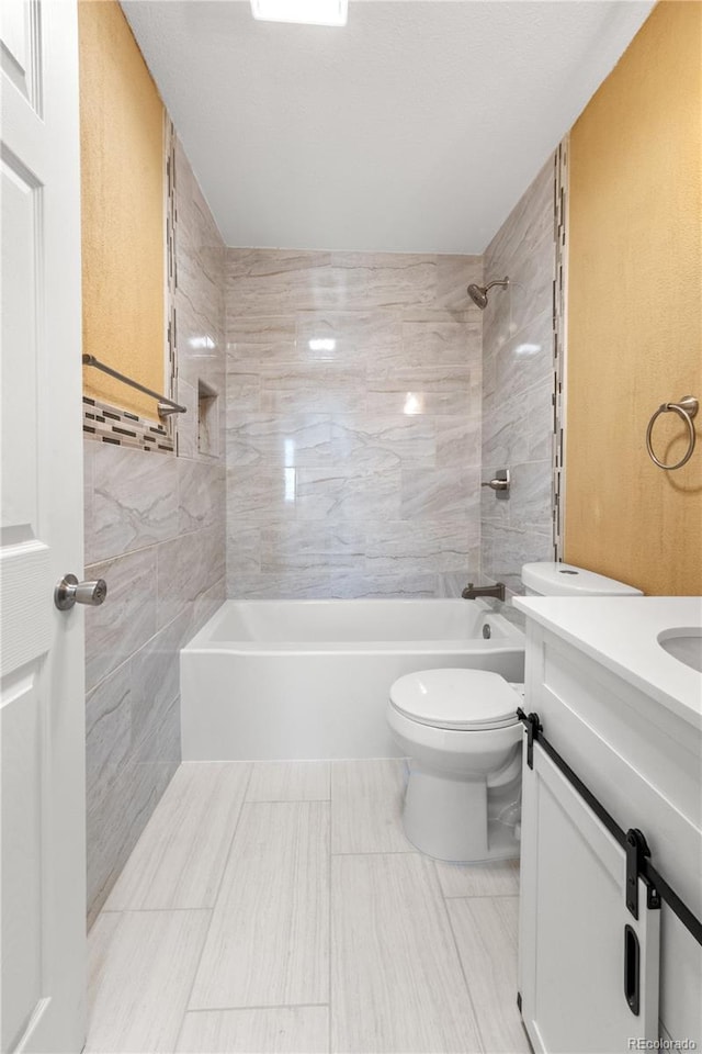 full bathroom with toilet, tiled shower / bath combo, and vanity