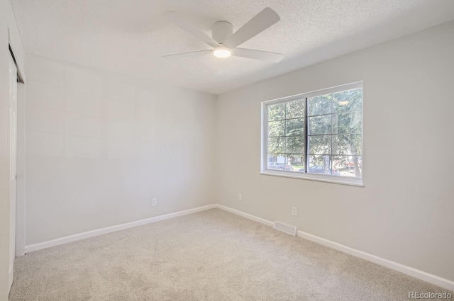 carpeted empty room with a textured ceiling and ceiling fan