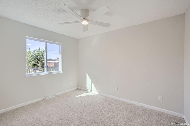 carpeted spare room with a textured ceiling and ceiling fan