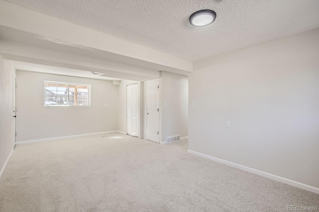 carpeted spare room featuring a textured ceiling