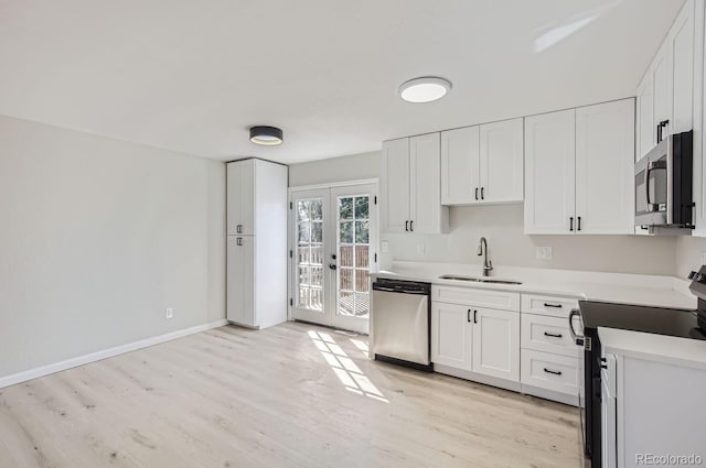 kitchen with french doors, stainless steel appliances, sink, and white cabinets